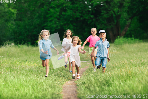 Image of Kids, children running on meadow in summer\'s sunlight