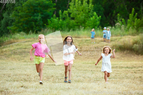 Image of Kids, children running on meadow in summer\'s sunlight