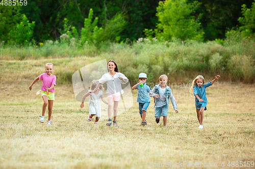 Image of Kids, children running on meadow in summer\'s sunlight