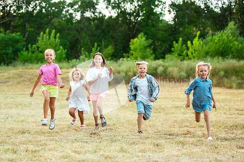 Image of Kids, children running on meadow in summer\'s sunlight