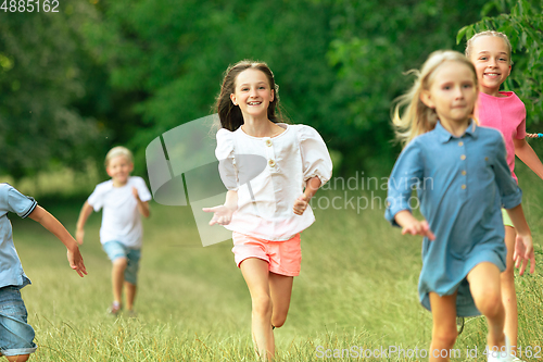 Image of Kids, children running on meadow in summer\'s sunlight