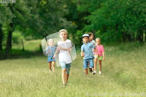 Image of Kids, children running on meadow in summer\'s sunlight