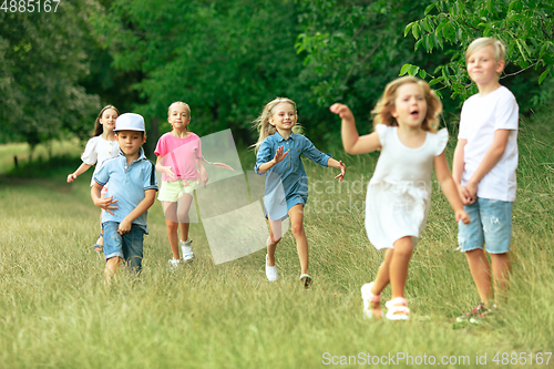 Image of Kids, children running on meadow in summer\'s sunlight