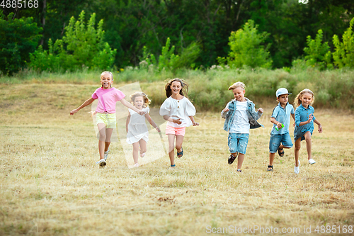 Image of Kids, children running on meadow in summer\'s sunlight