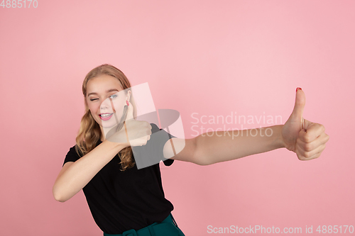 Image of Young emotional woman on pink studio background. Human emotions, facial expression concept.
