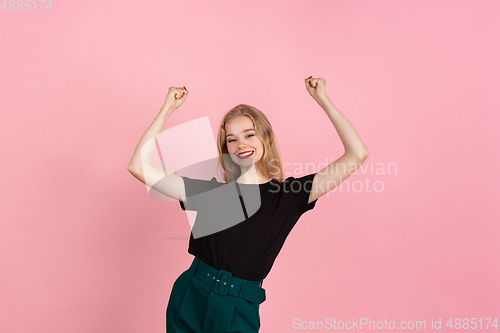 Image of Young emotional woman on pink studio background. Human emotions, facial expression concept.