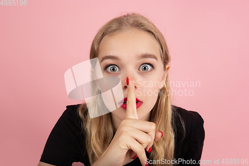 Image of Young emotional woman on pink studio background. Human emotions, facial expression concept.