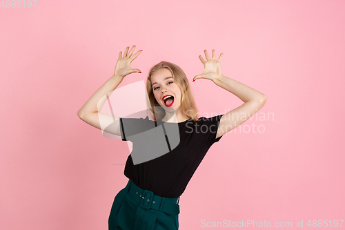 Image of Young emotional woman on pink studio background. Human emotions, facial expression concept.