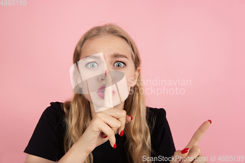 Image of Young emotional woman on pink studio background. Human emotions, facial expression concept.