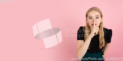 Image of Young emotional woman on pink studio background. Human emotions, facial expression concept.