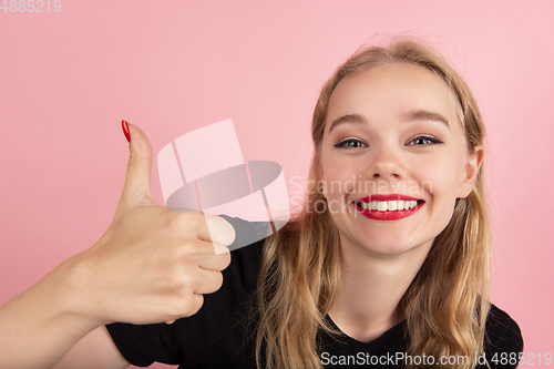 Image of Young emotional woman on pink studio background. Human emotions, facial expression concept.