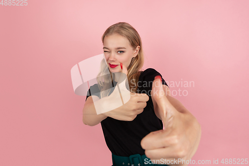 Image of Young emotional woman on pink studio background. Human emotions, facial expression concept.