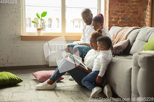 Image of Young african family during quarantine, insulation spending time together at home