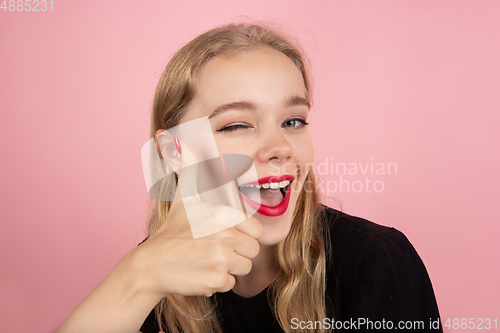 Image of Young emotional woman on pink studio background. Human emotions, facial expression concept.
