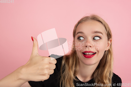 Image of Young emotional woman on pink studio background. Human emotions, facial expression concept.