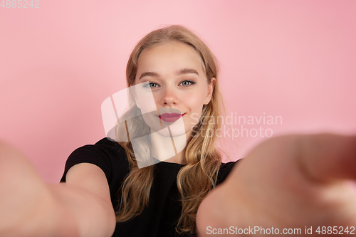 Image of Young emotional woman on pink studio background. Human emotions, facial expression concept.