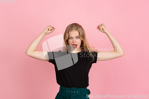 Image of Young emotional woman on pink studio background. Human emotions, facial expression concept.