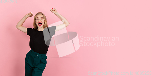 Image of Young emotional woman on pink studio background. Human emotions, facial expression concept.