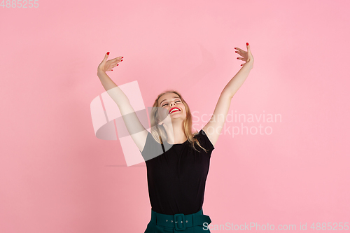 Image of Young emotional woman on pink studio background. Human emotions, facial expression concept.