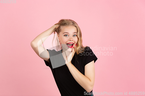 Image of Young emotional woman on pink studio background. Human emotions, facial expression concept.