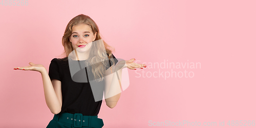 Image of Young emotional woman on pink studio background. Human emotions, facial expression concept.
