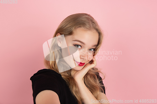 Image of Young emotional woman on pink studio background. Human emotions, facial expression concept.