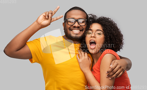 Image of happy african american couple in glasses hugging