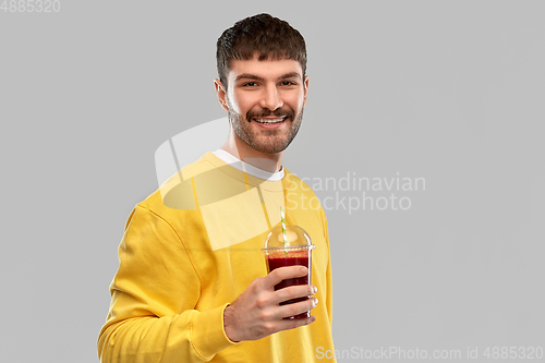 Image of happy man with tomato juice in takeaway cup