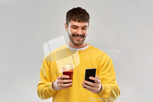 Image of happy man with smartphone and tomato juice