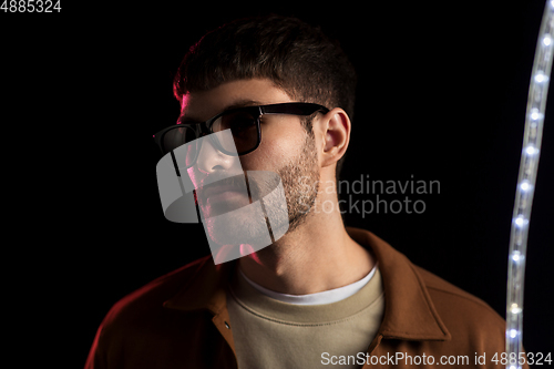 Image of man in sunglasses over neon lights at nightclub