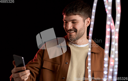 Image of happy smiling young man with smartphone