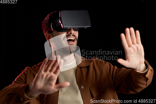 Image of happy man in vr glasses over black background