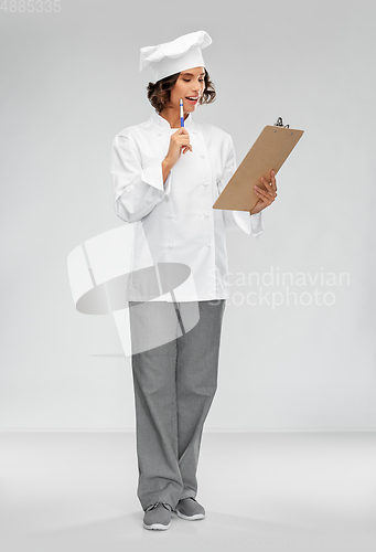 Image of smiling female chef in toque with clipboard