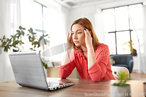 Image of stressed woman with laptop working at home office