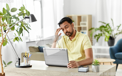 Image of indian man with laptop working at home office