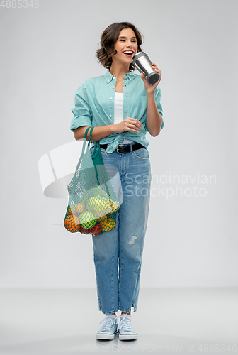 Image of happy smiling woman with food in reusable net bag