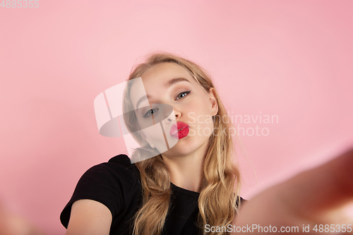 Image of Young emotional woman on pink studio background. Human emotions, facial expression concept.
