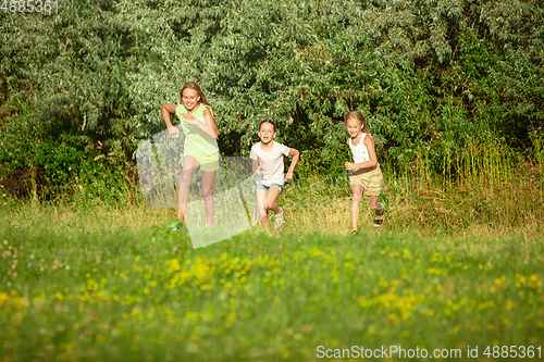 Image of Kids, children running on meadow in summer\'s sunlight