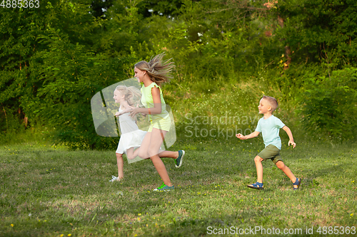 Image of Kids, children running on meadow in summer\'s sunlight