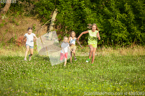 Image of Kids, children running on meadow in summer\'s sunlight