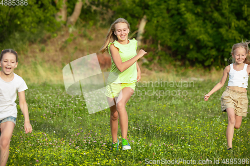 Image of Kids, children running on meadow in summer\'s sunlight