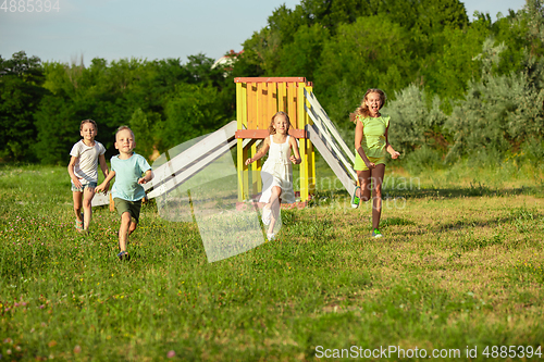 Image of Kids, children running on meadow in summer\'s sunlight