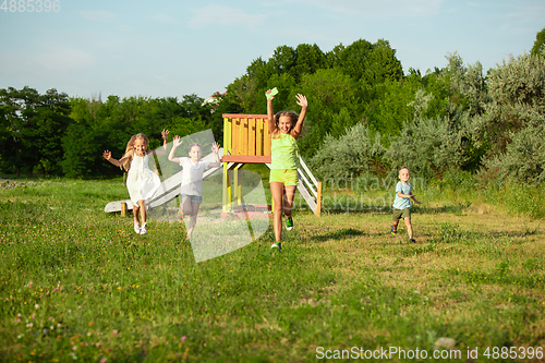 Image of Kids, children running on meadow in summer\'s sunlight