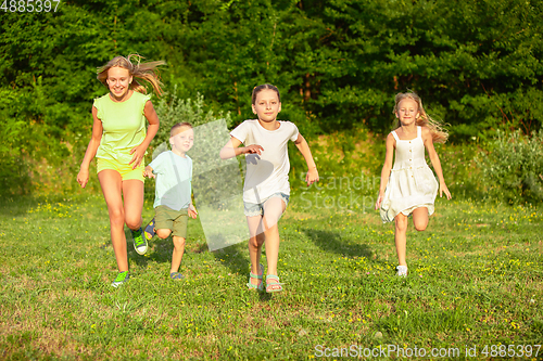 Image of Kids, children running on meadow in summer\'s sunlight
