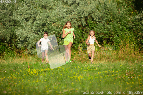 Image of Kids, children running on meadow in summer\'s sunlight