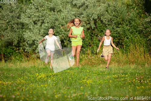 Image of Kids, children running on meadow in summer\'s sunlight