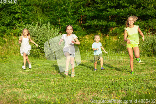 Image of Kids, children running on meadow in summer\'s sunlight