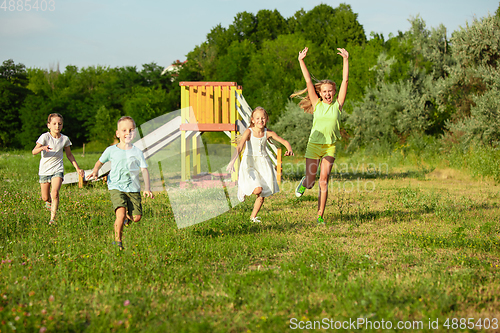 Image of Kids, children running on meadow in summer\'s sunlight