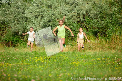 Image of Kids, children running on meadow in summer\'s sunlight