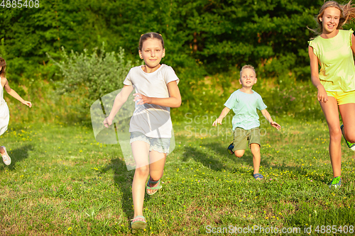 Image of Kids, children running on meadow in summer\'s sunlight